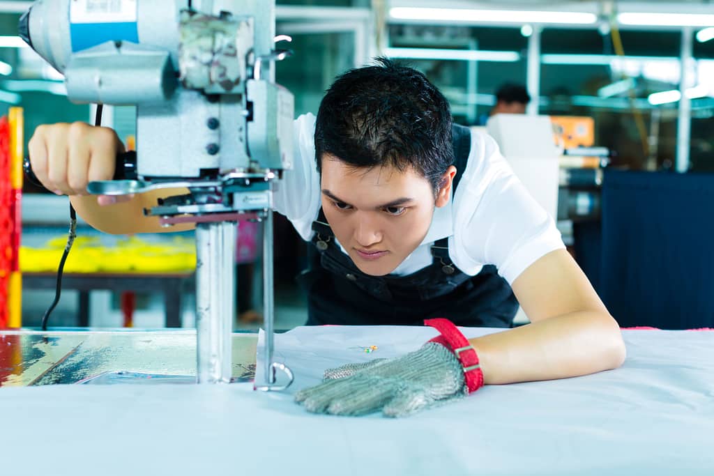 worker using machine to cut the fabric