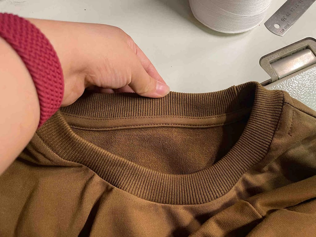 Single needle topstitching on back neck tape